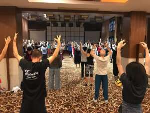 personas practicando qigong y elevando los brazos
